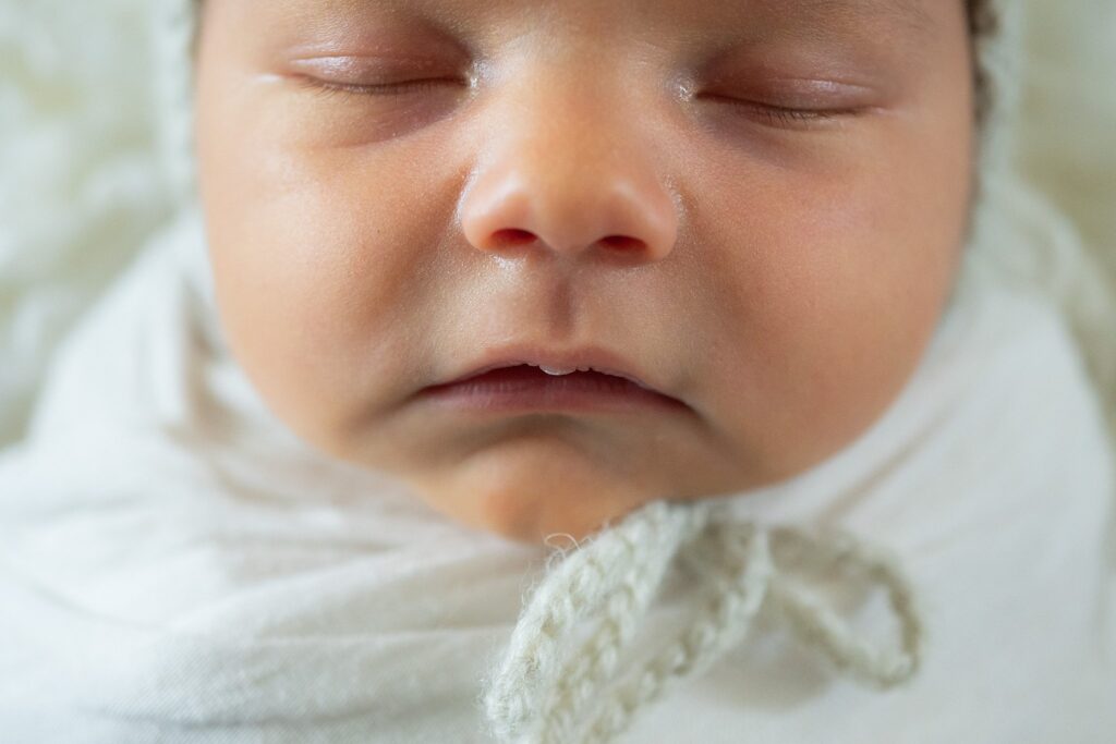 A close-up of baby James’ tiny toes and soft curls, captured in soft natural light. The muted olive green background nods to the family’s love for Ireland during this in-home newborn session in Sacramento.
